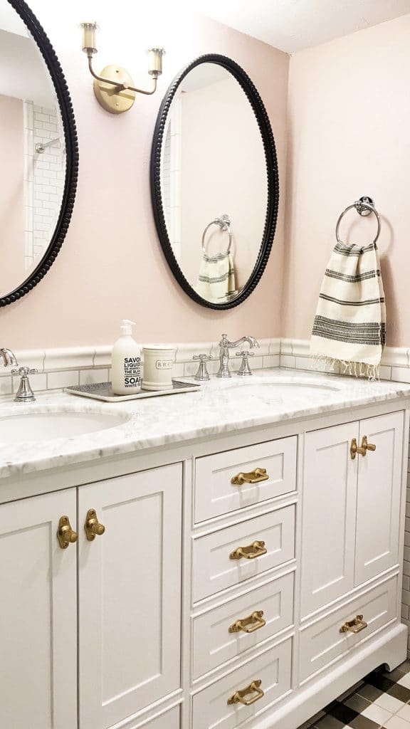 Bathroom with black mirrors and white cabinets