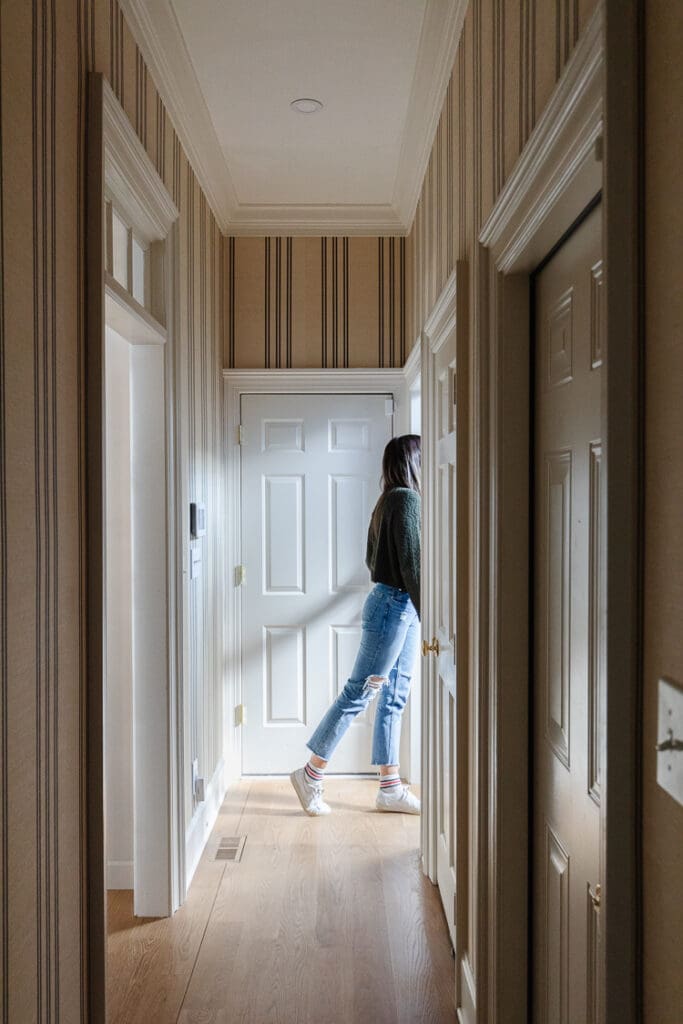 Julia stepping out of the back hallway with wood floors