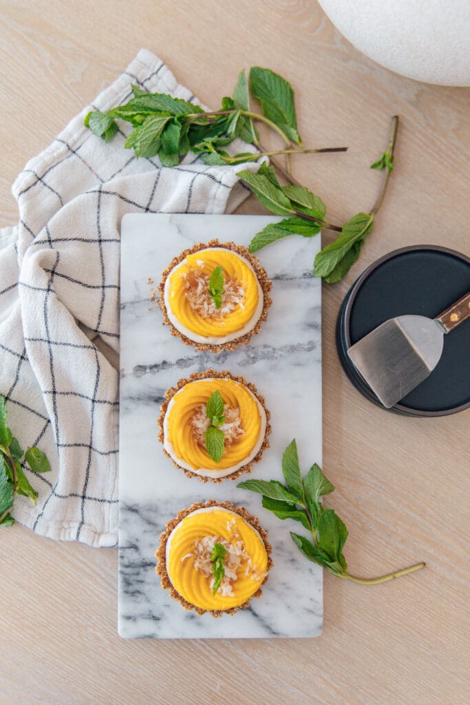 Coconut Mango Breakfast Tarts in a line on a marble cutting board