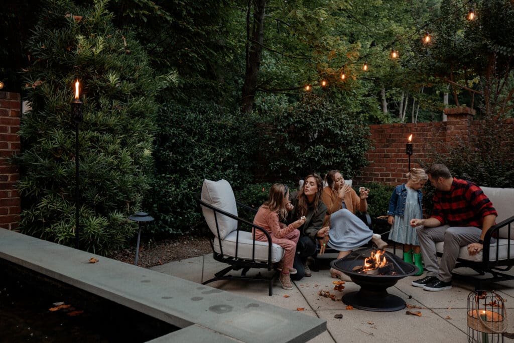 The Marcum family in their pre-renovated backyard around a fire pit