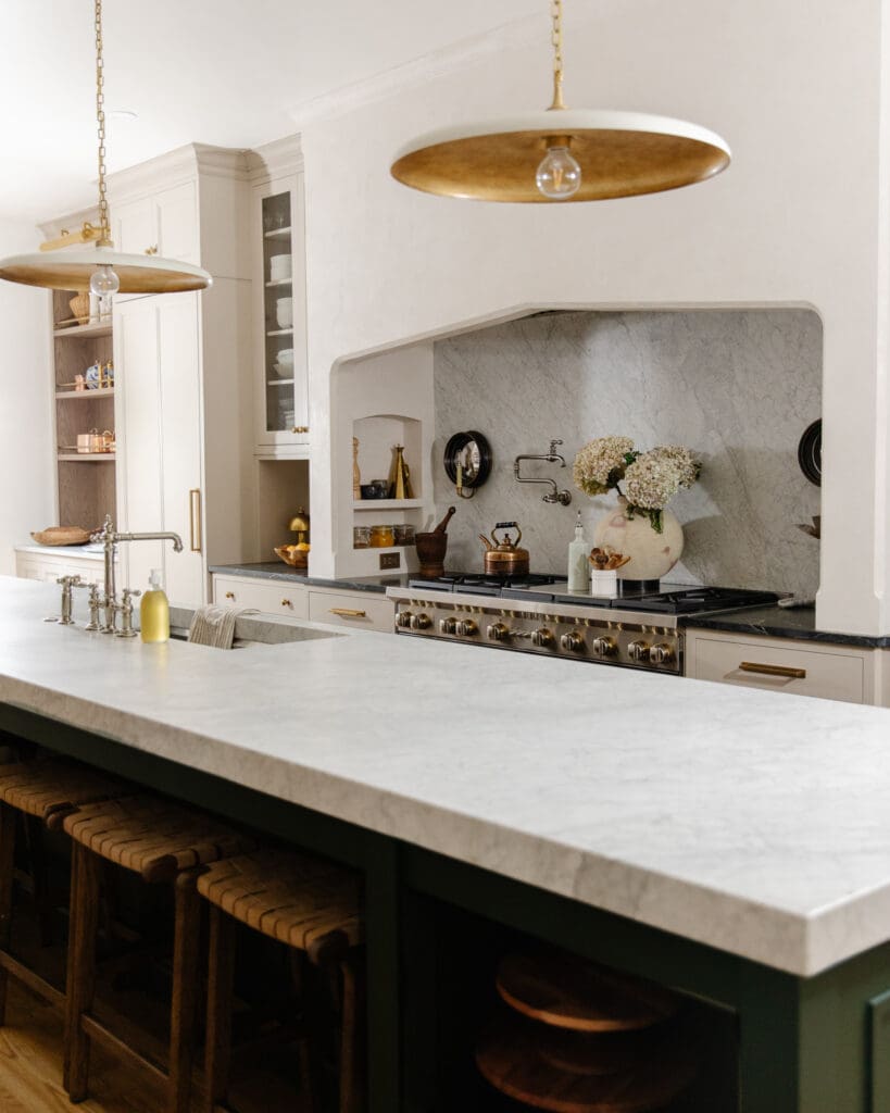 Long marble countertop on a dark green island