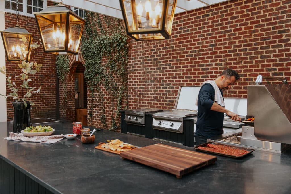 Chris cooking on a grill in the outdoor kitchen