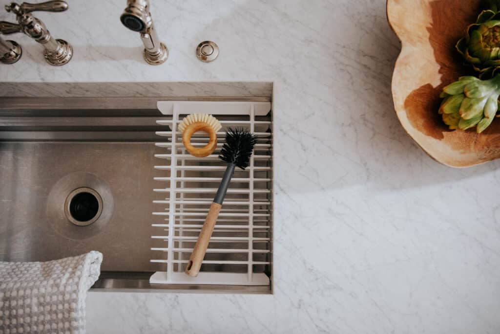 A marble countertop with aesthetic cleaning scrub brush and bottle brush