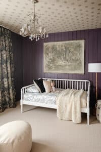 Polly's purple bedroom with large wall tapestry and chandelier