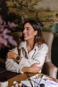 Julia looking tanned in a cozy zip-up jacket in her office