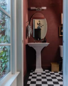 Powder bath with roman clay walls and black & white floor tiles FloorPops