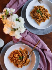 Delicious pasta with rich tomato sauce and fresh herbs served on white plates. Perfect for family dinners or cozy nights at home.