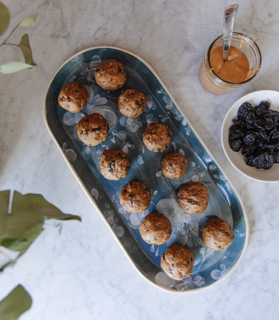 Delicious homemade energy bites with oats, nuts, and chocolate chips arranged on a stylish blue ceramic plate, perfect for a nutritious snack.