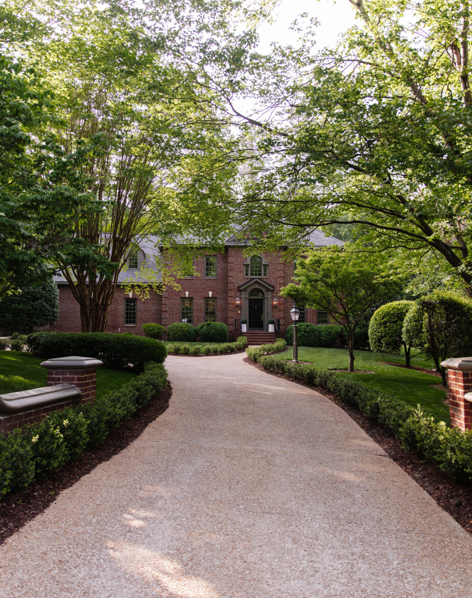 Driveway entrance to grand brick colonial home with Cromwell Gray exterior trim paint