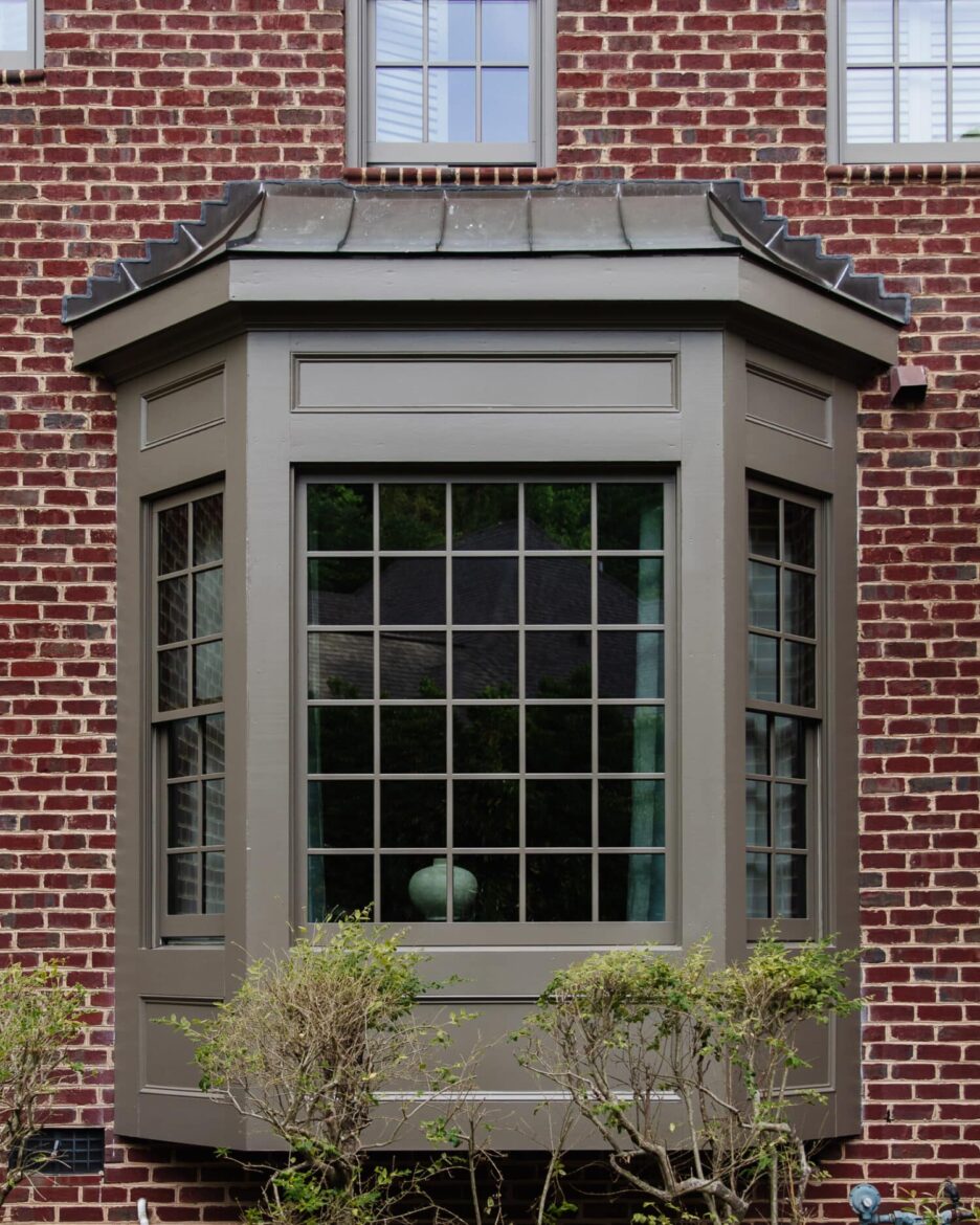 Exterior dark moody paint color on brick home windows