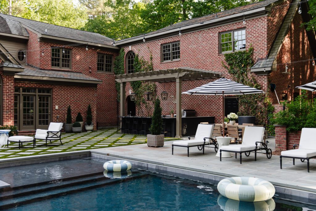 Beautiful outdoor living space featuring a swimming pool, lounge chairs, and a shaded patio area, perfect for summer gatherings and holiday celebrations.