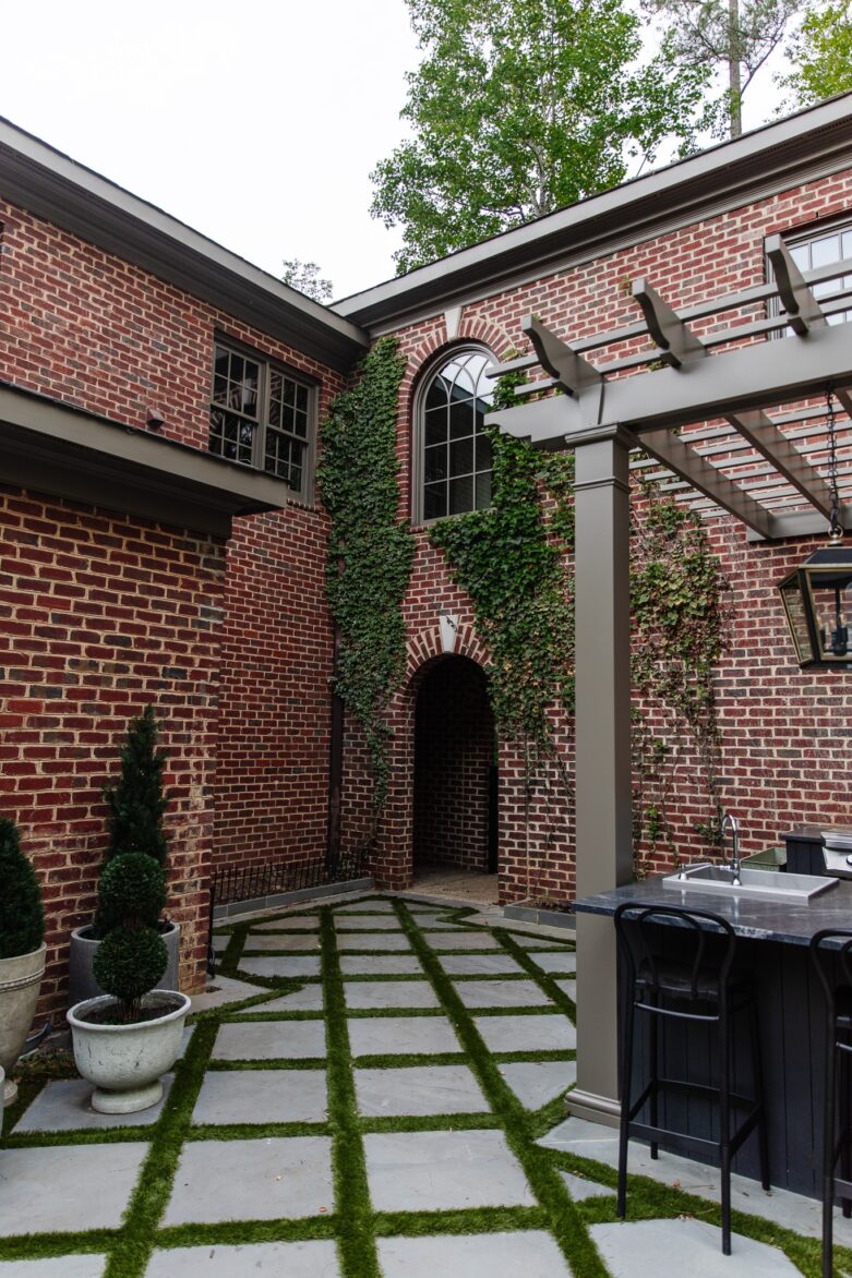 Outdoor Kitchen with Pergola Painted in Cromwell Gray, a Moody Brown Color and Ivy on Brick
