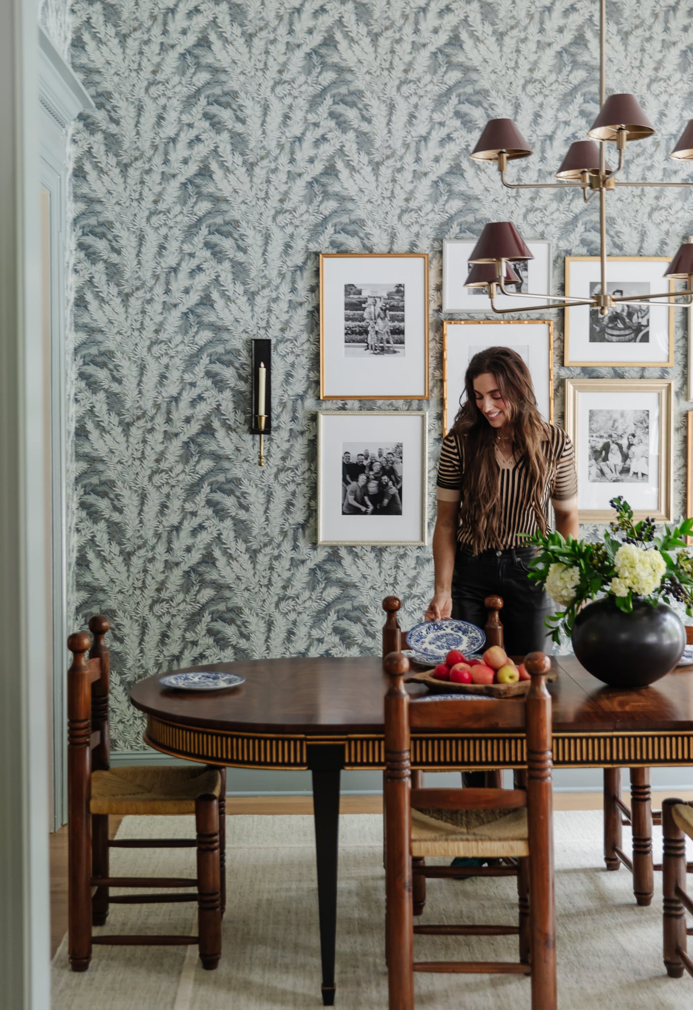 Chris Loves Julia | Julia in front of family photographs on the dining room wall