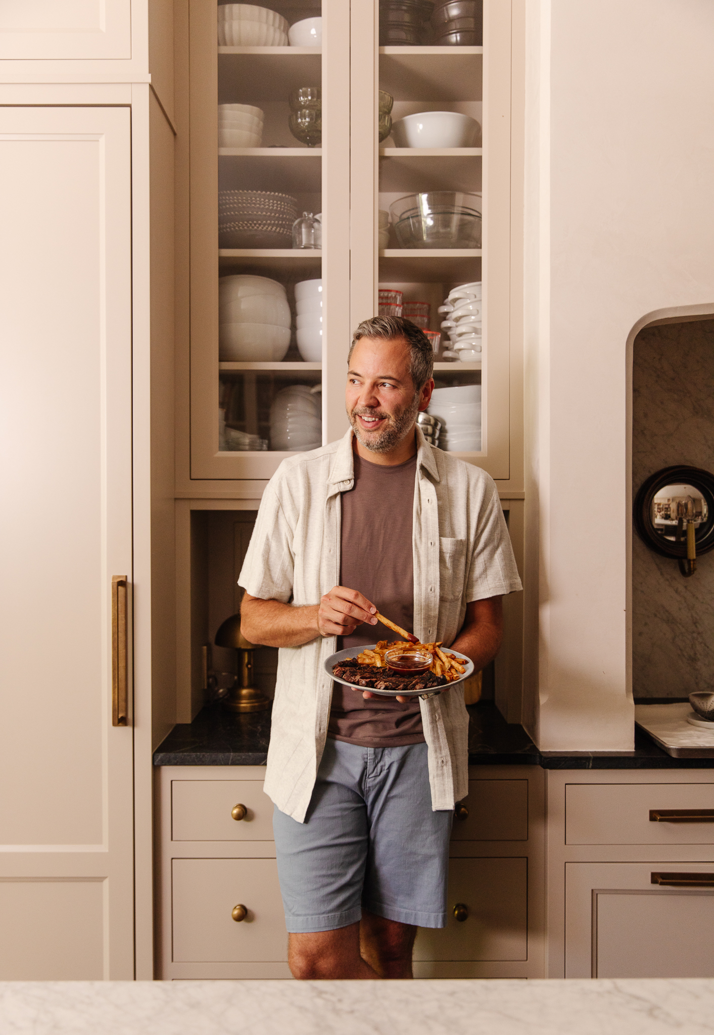 Chris Loves Julia | Chris standing in the kitchen holding a plate of Steak Frites