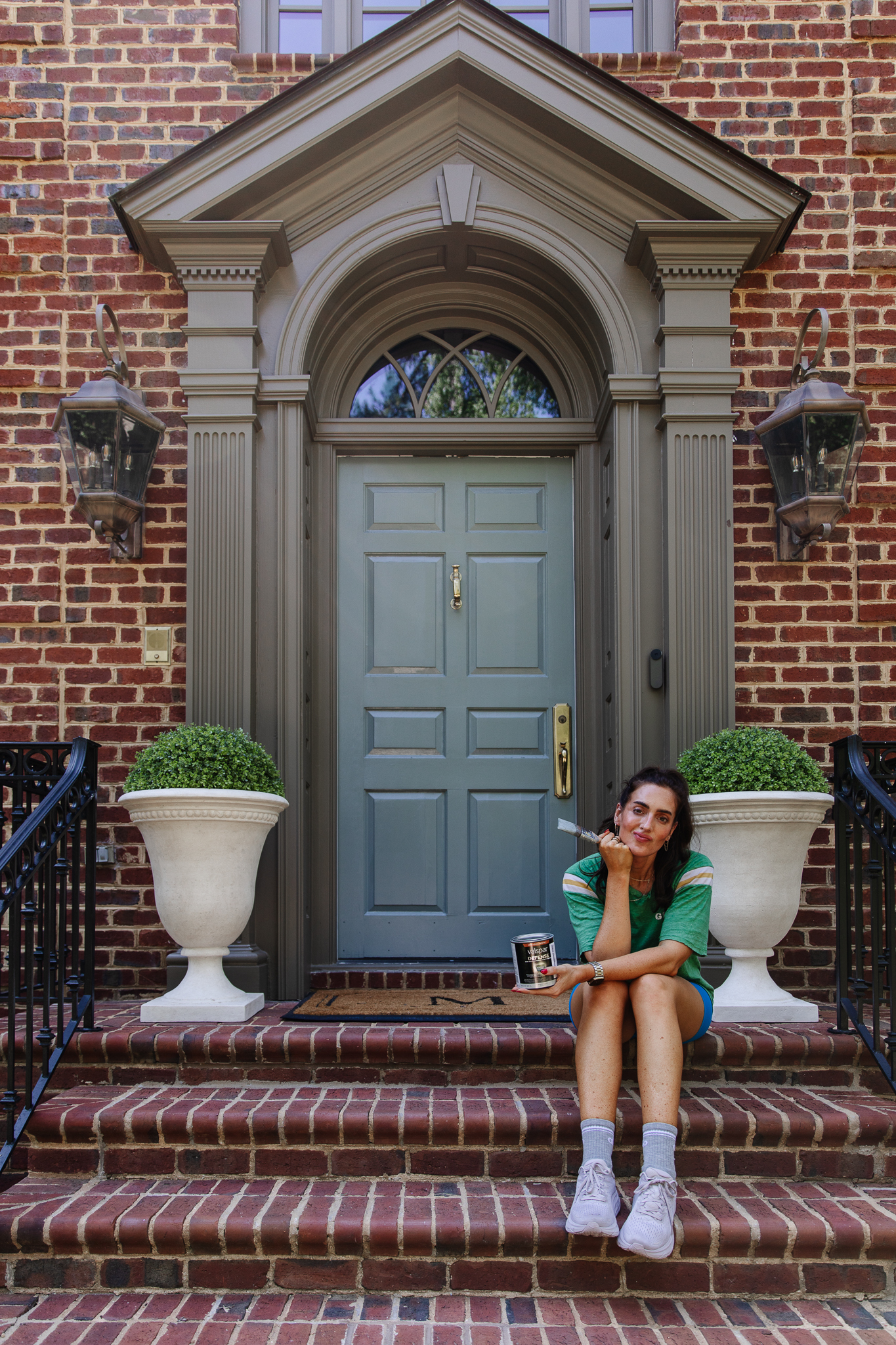 Chris Loves Julia | Julia sitting in front of the front door painted in De Nimes by Farrow & Ball