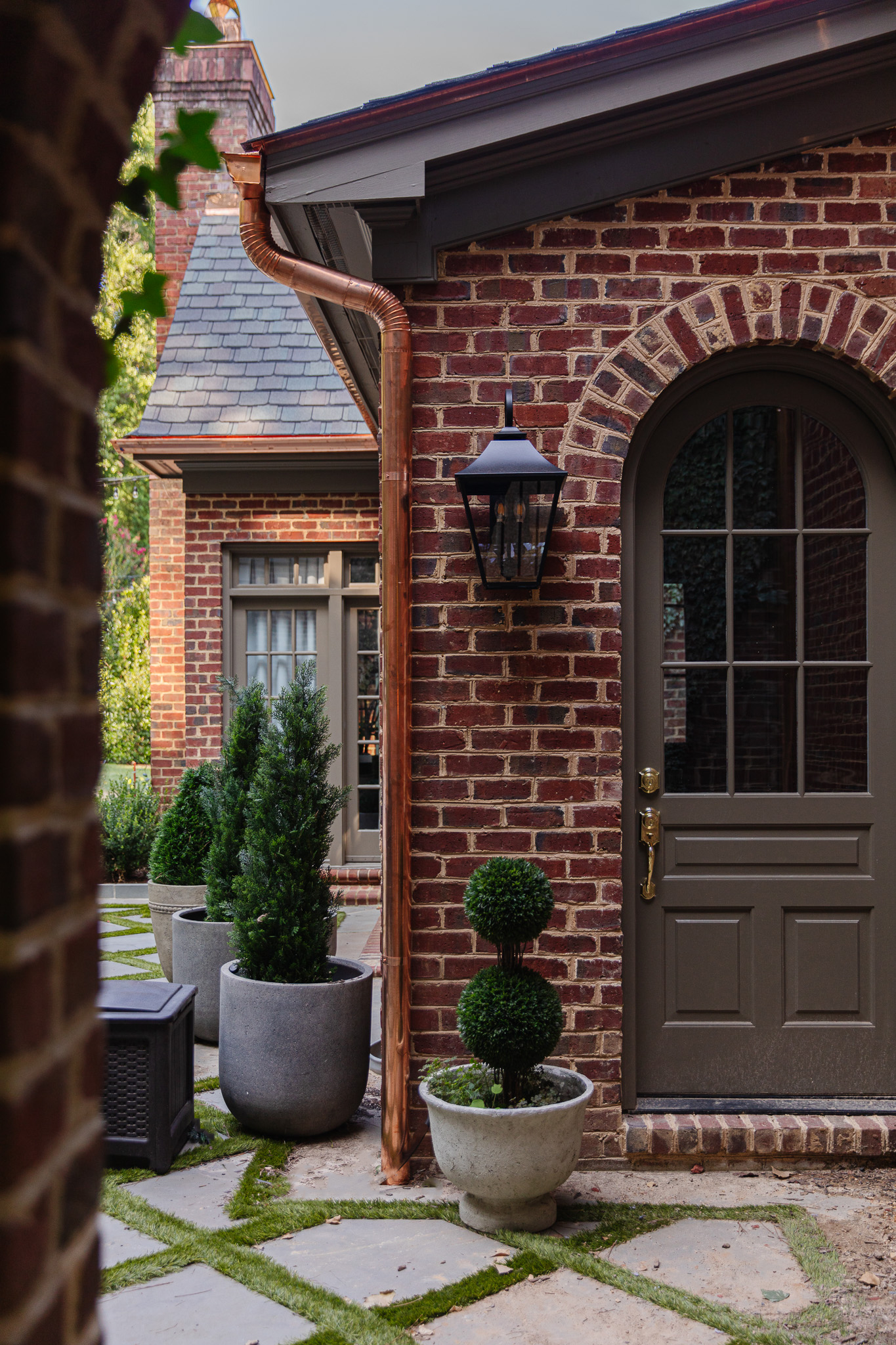 Chris Loves Julia | Traditional brick house with new barrel downpipe copper gutters around the exterior mudroom door