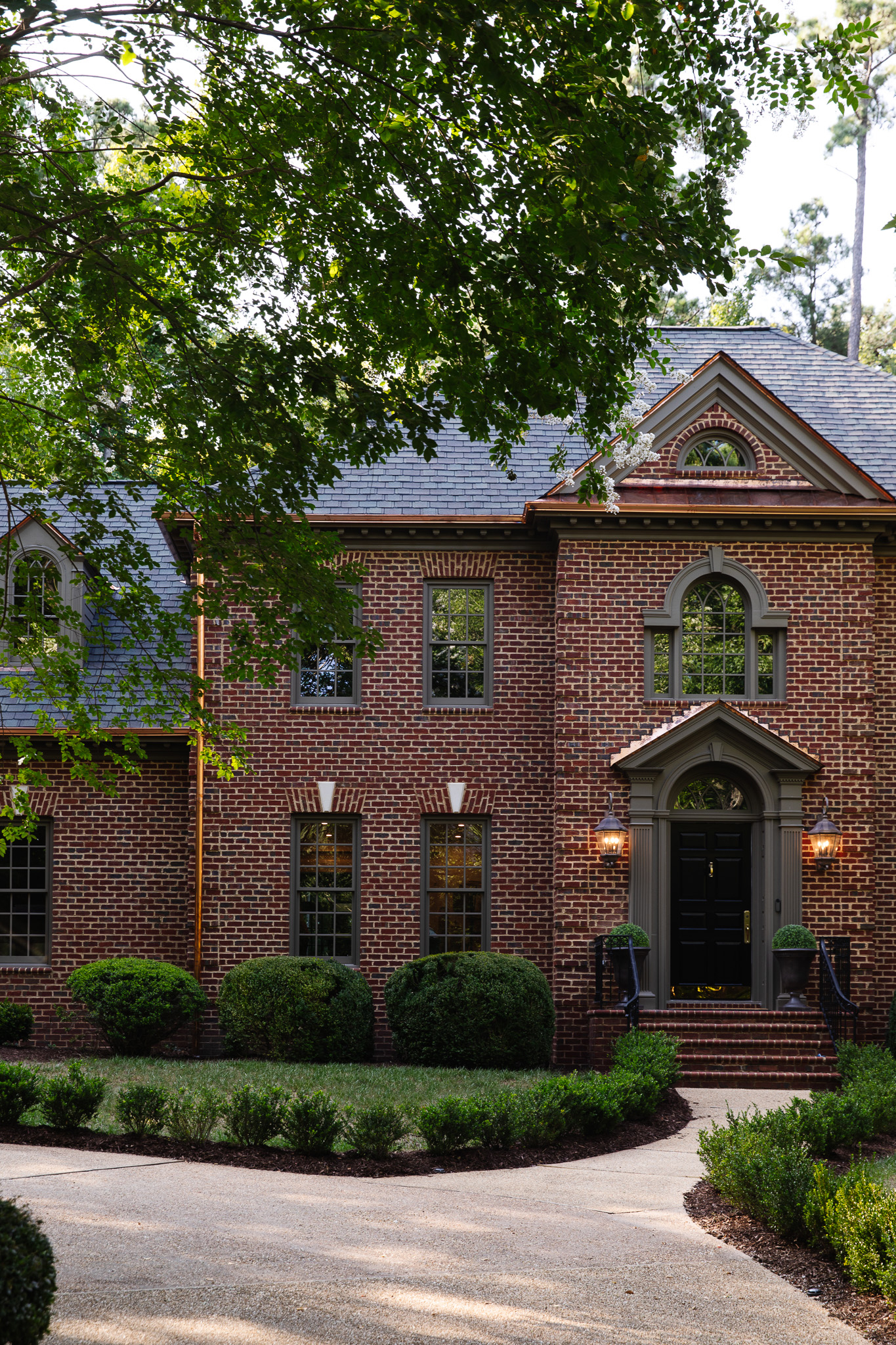 Chris Loves Julia | Front of a traditional brick house with new copper gutters and flashing