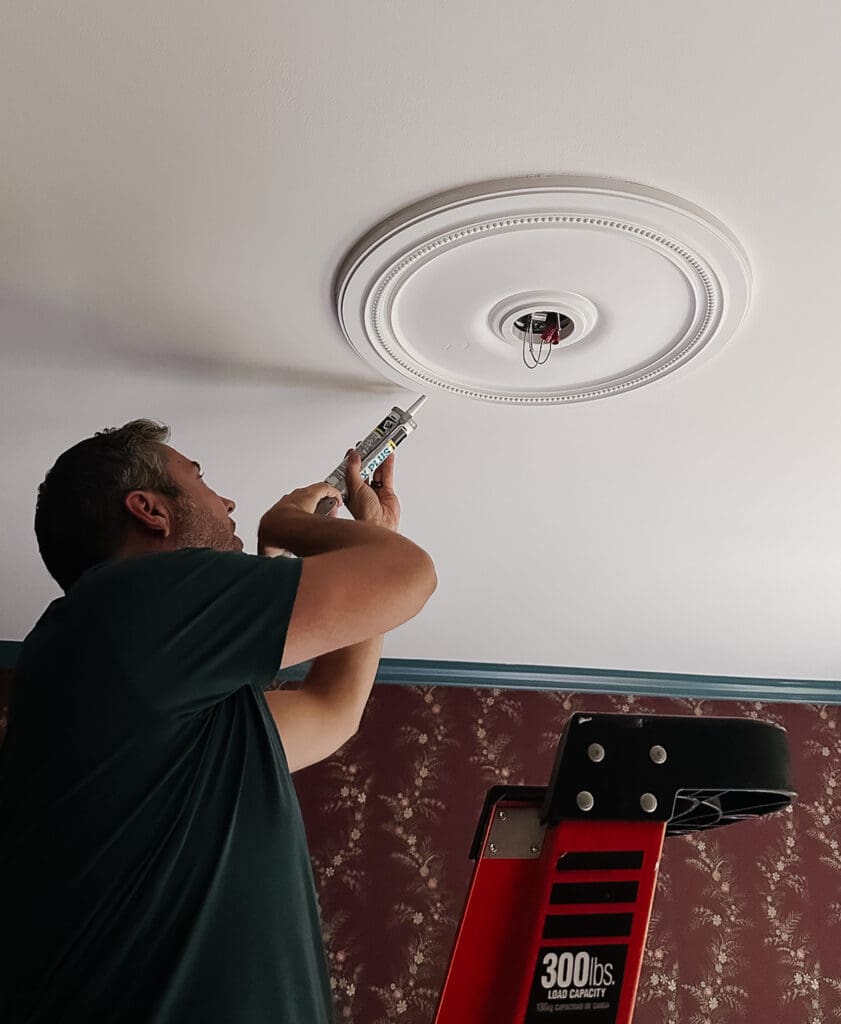 Chris Loves Julia | Chris caulking the exterior rim of the white ceiling medallion in Greta's room