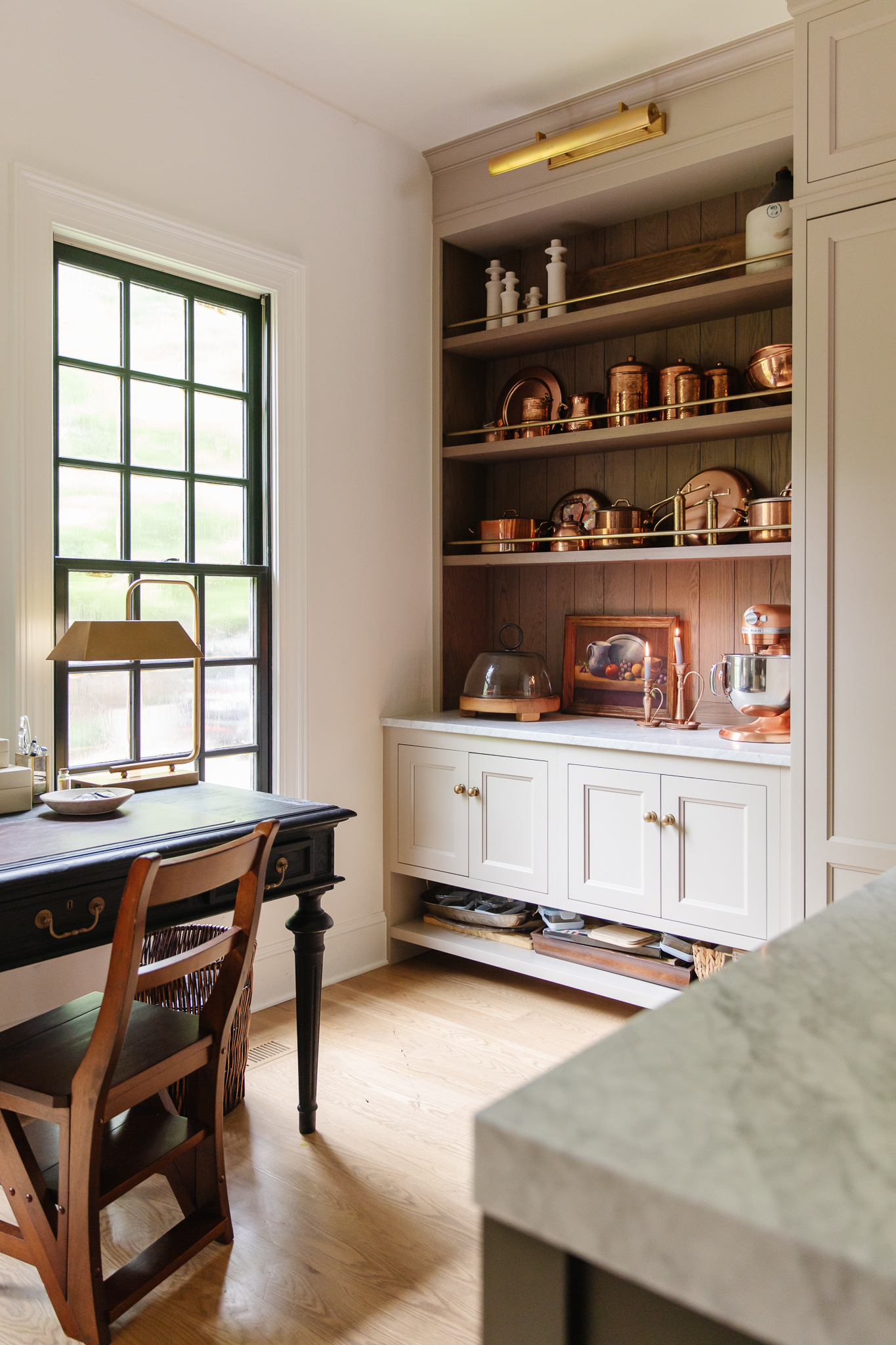 Chris Loves Julia | The open kitchen shelves with a large picture light overhead