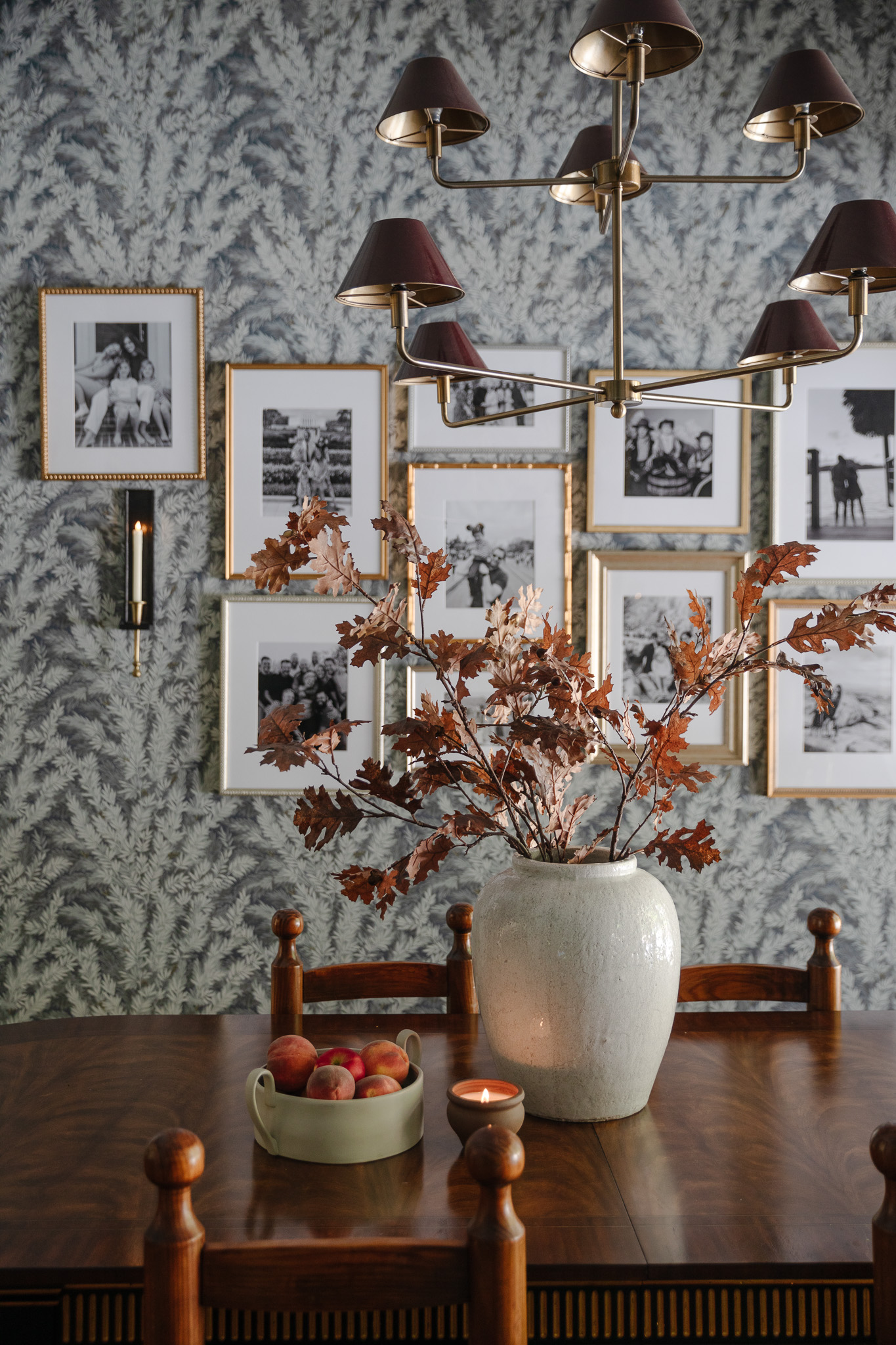 Chris Loves Julia | Dining room with a vase of fall stems, a bowl of peaches and a candle