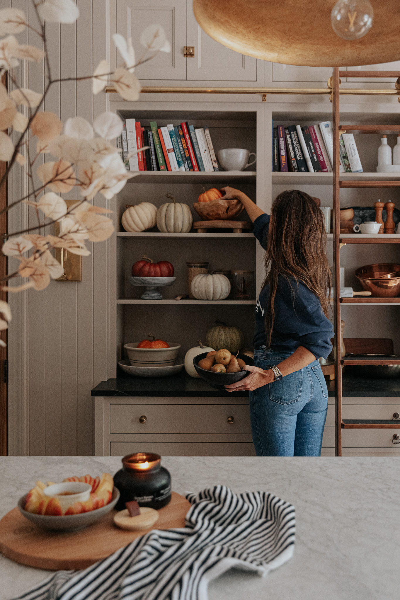 Chris Loves Julia | Julia placing a faux pumpkin on her kitchen shelf