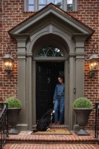 Julia standing at the front door of the Modern Colonial home in denim-on-denim clothes