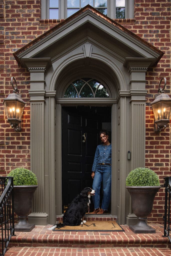Julia standing at the front door of the Modern Colonial home in denim-on-denim clothes
