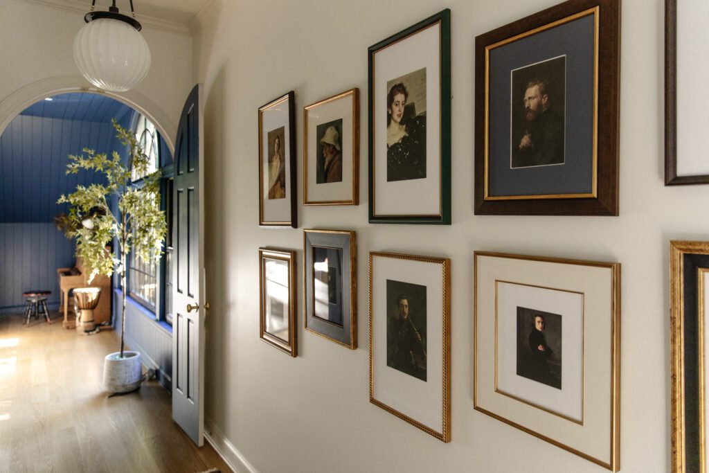 A gallery wall of Framebridge framed prints of historic paintings in a hallway