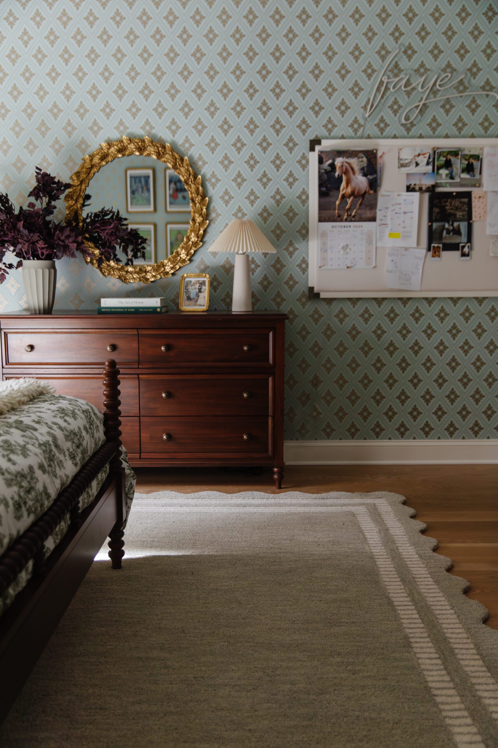 Scalloped-edge mist-gray rug in a room with a dresser and gold mirror