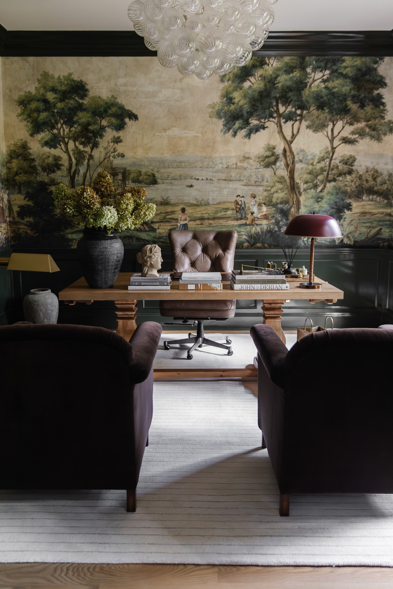 A study with two armchairs, a desk and a white striped rug