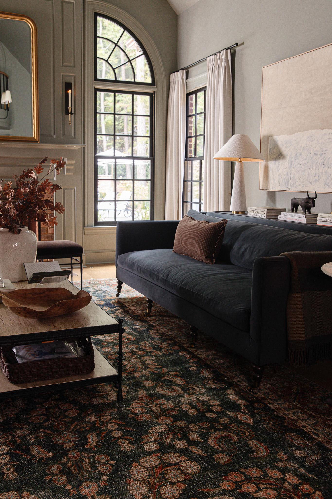 Living room with blue couch and vintage-looking navy and red rug