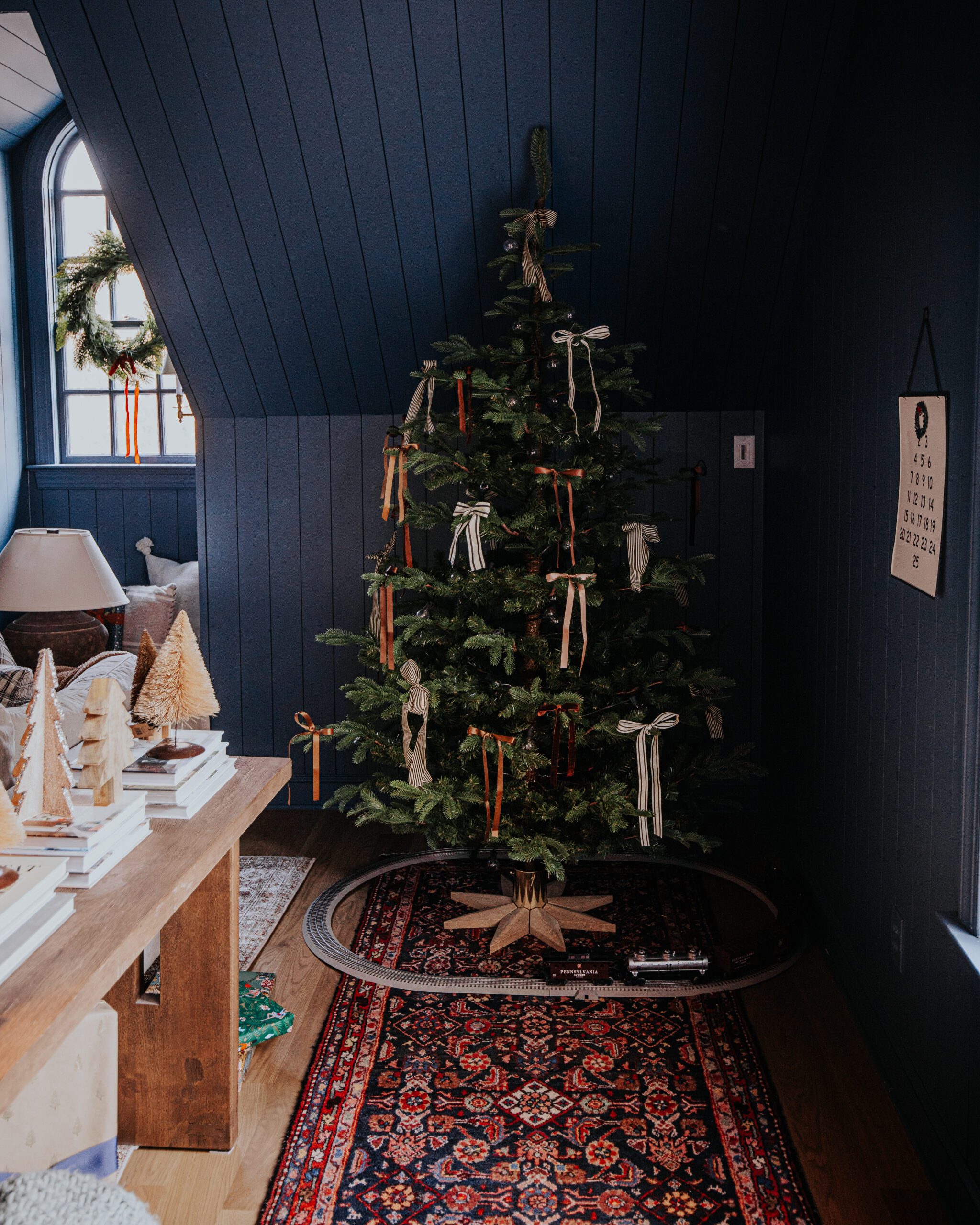 A traditional Christmas tree with ribbon bows in the bonus room