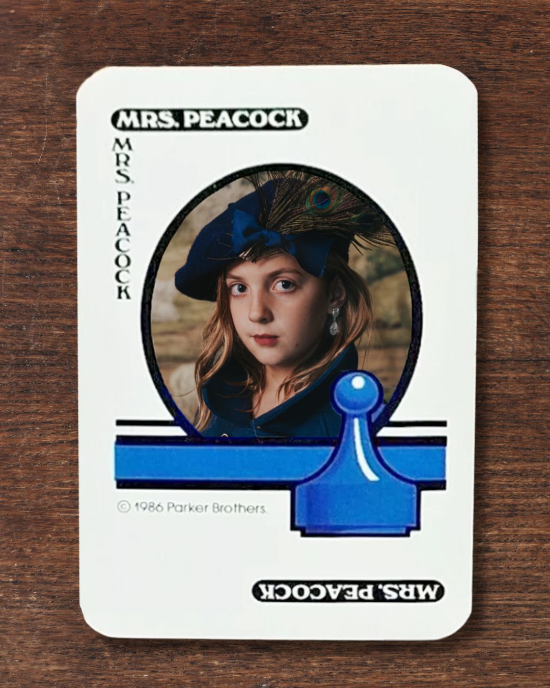 Girl dressed as Mrs. Peacock on a classic playing card from Clue: The Game.