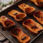 Roasted honeynut squash halves on a pan