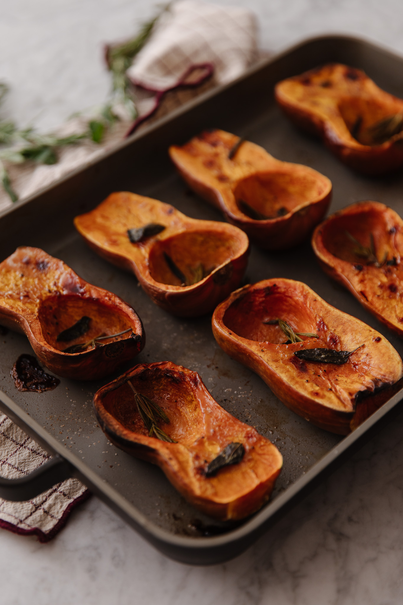 Roasted honeynut squash halves on a pan