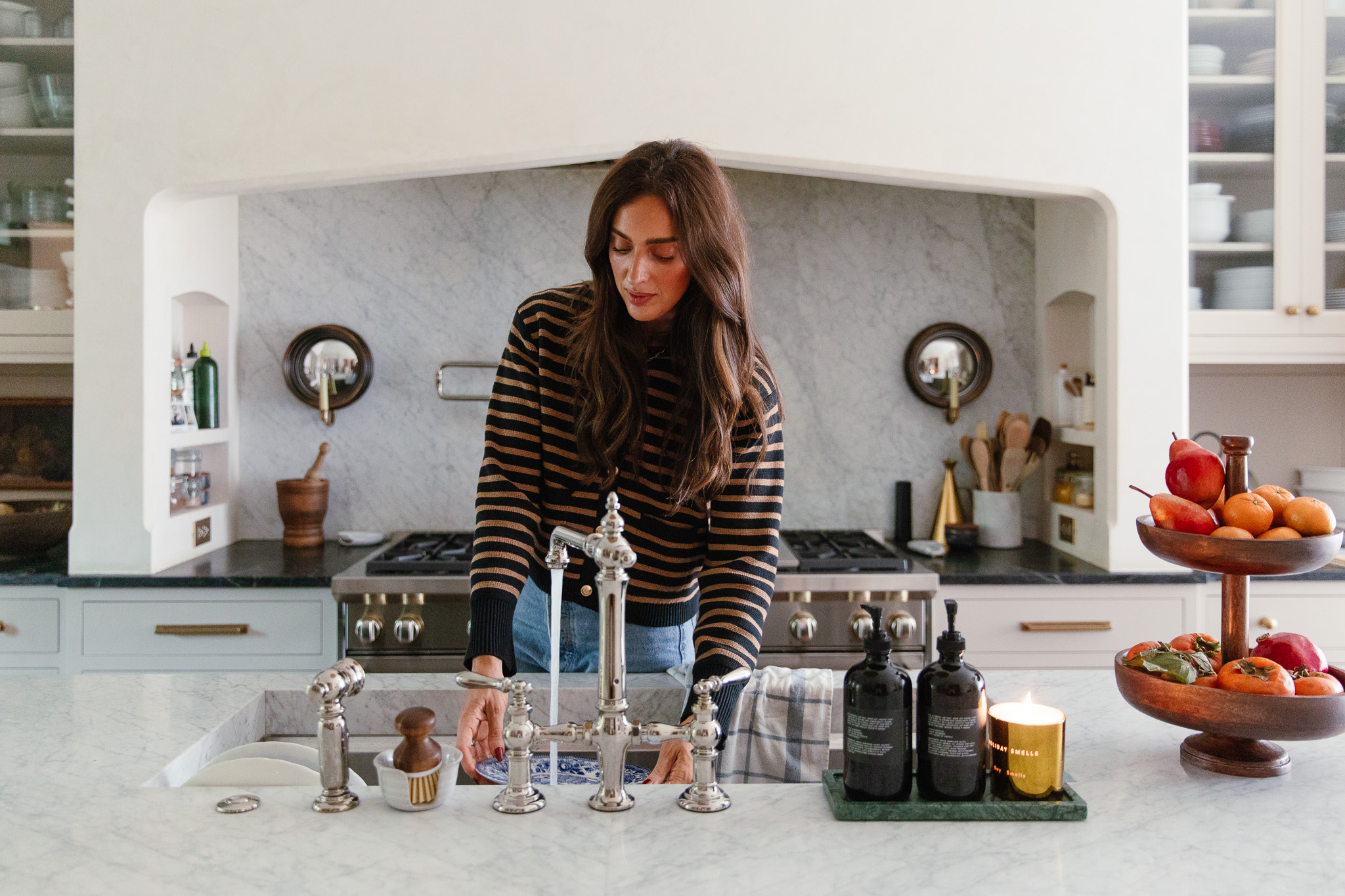 Julia standing at the sink behind a faucet of running water