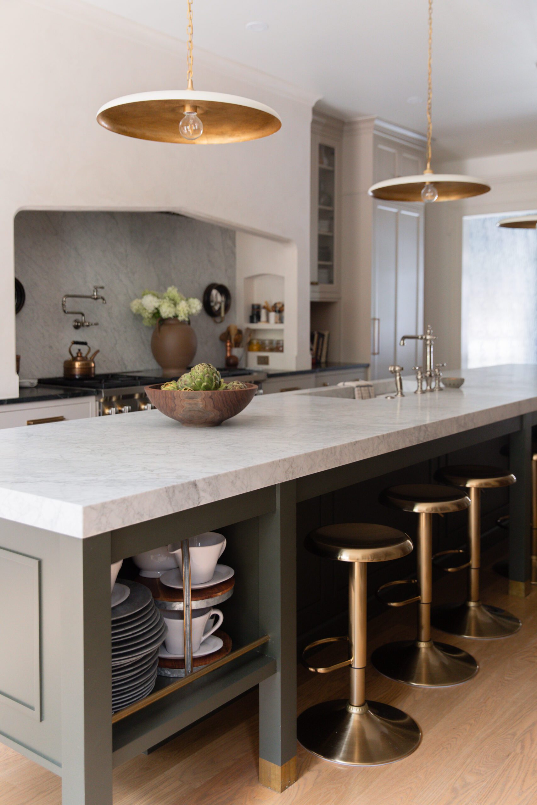 Modern traditional kitchen with marble island and gold barstools