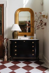 A front entry dresser featuring FloorPops peel-and-stick floor tiles in red & white marble checkerboard