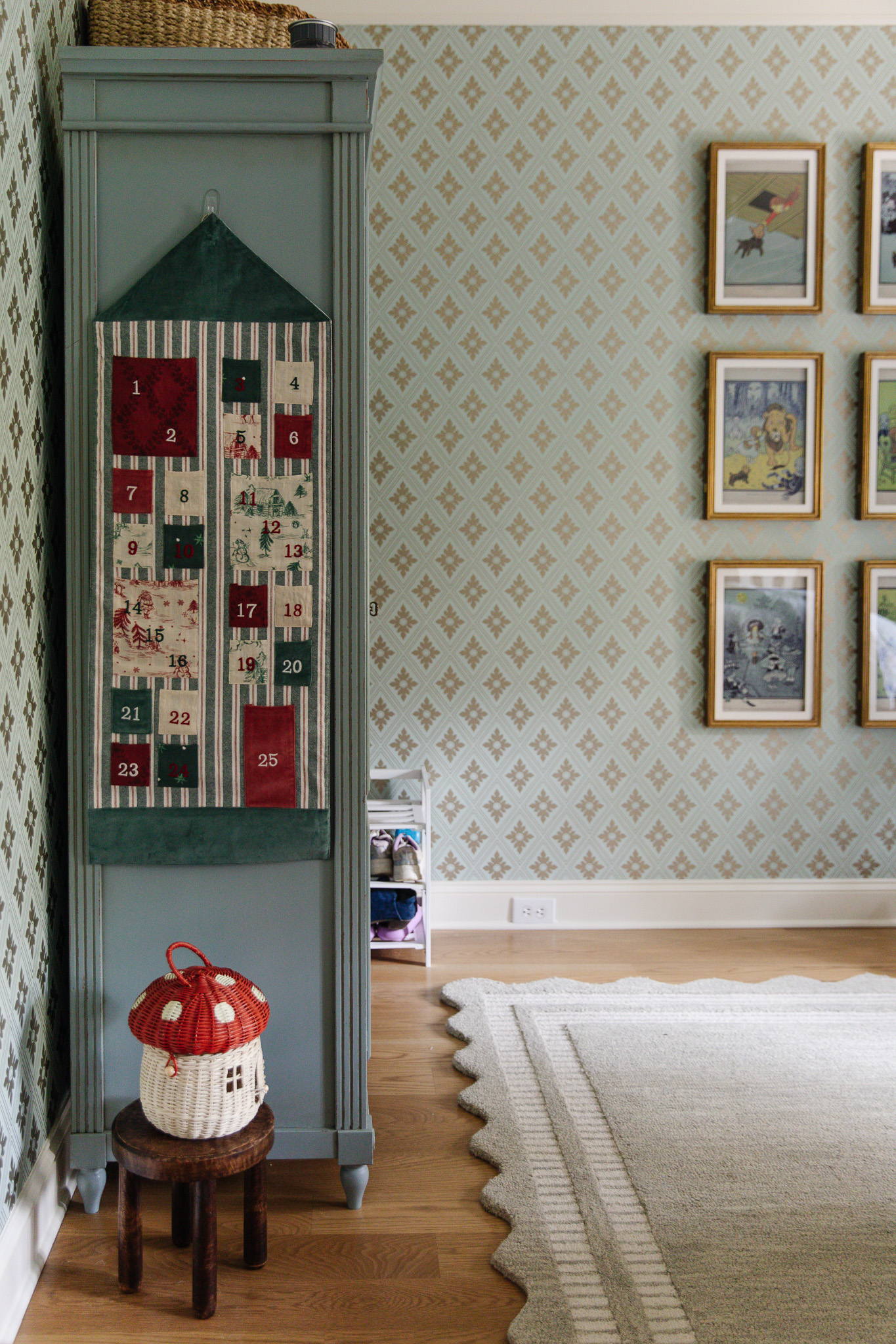 A hanging fabric advent calendar on the side of a blue armoire in a little kid's bedroom