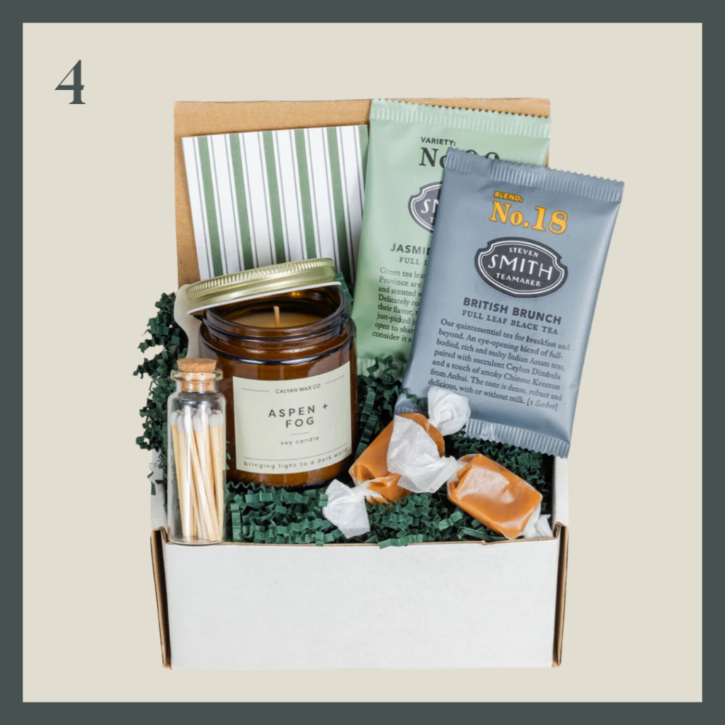 A gift box filled with candle, tea, matches and caramels