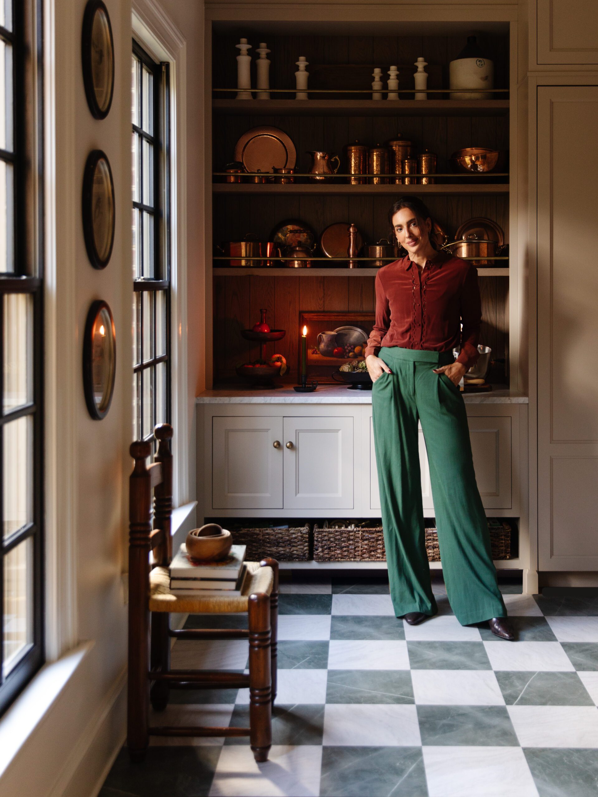 Julia standing in the kitchen with a floor featuring FloorPops peel-and-stick floor tiles in green & white marble checkerboard