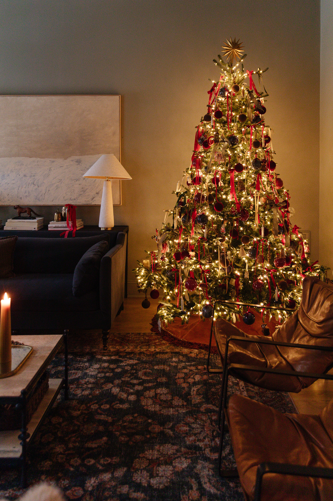 A Christmas tree lit at night with maximalist, traditional Christmas decorations