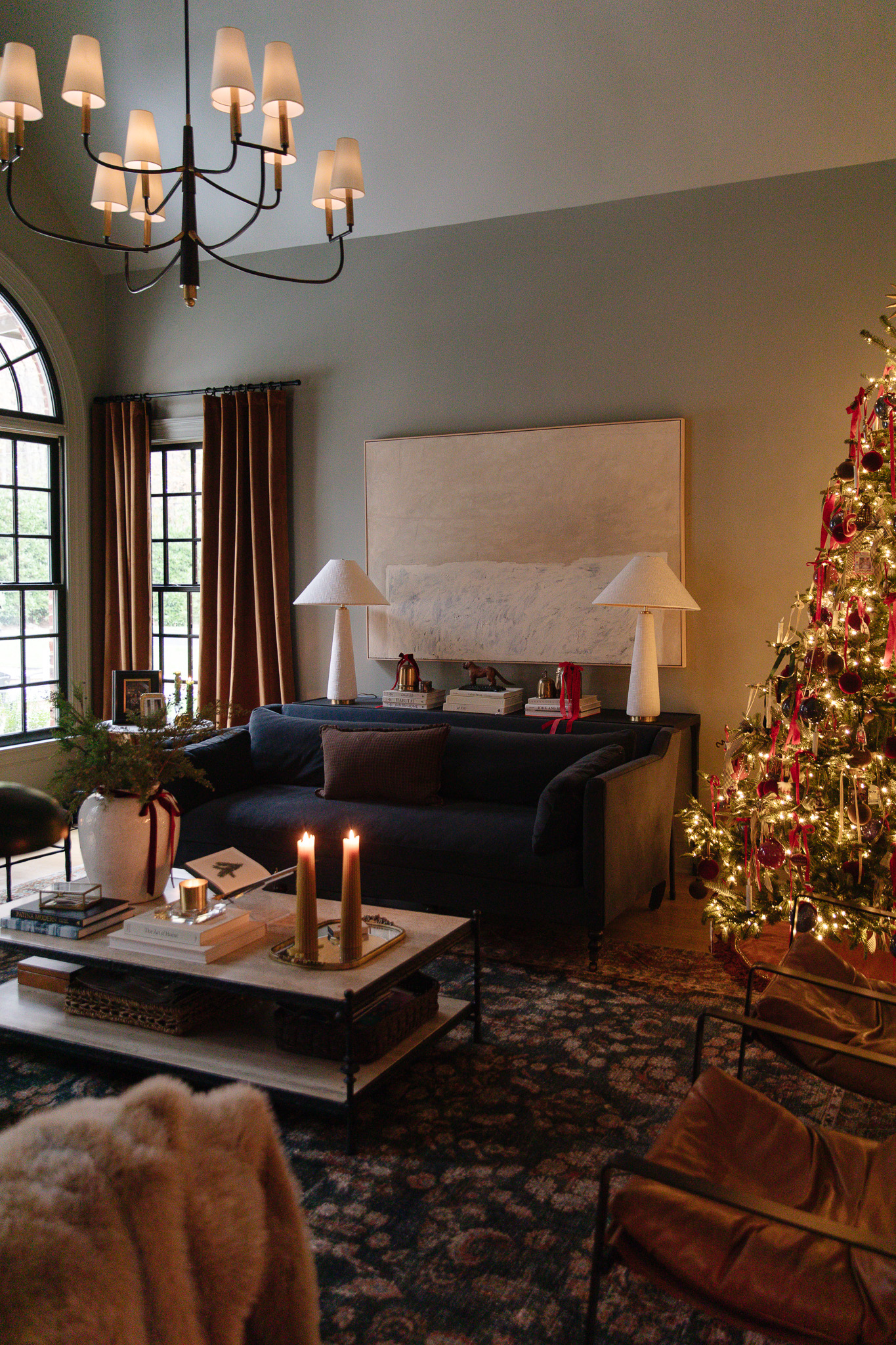 Christmas decorations in a living room with a gold, silver and red-trimmed Christmas tree and vintage brass bells as decor