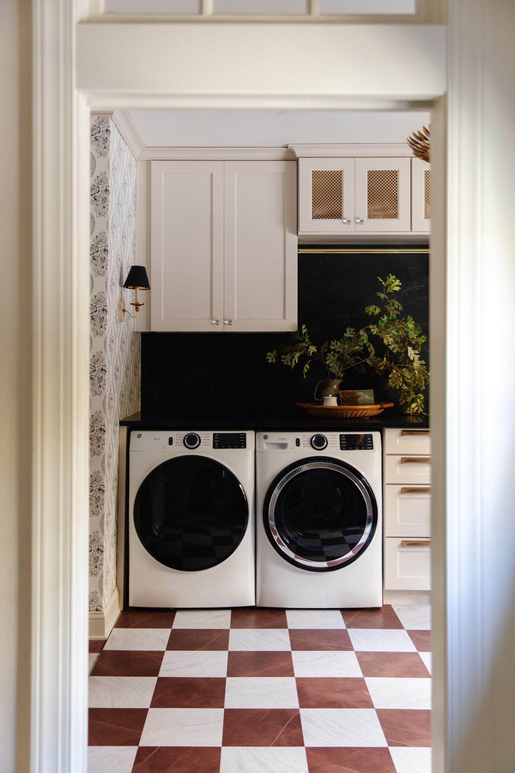 A laundry room floor featuring floor tiles in red & white marble checkerboard