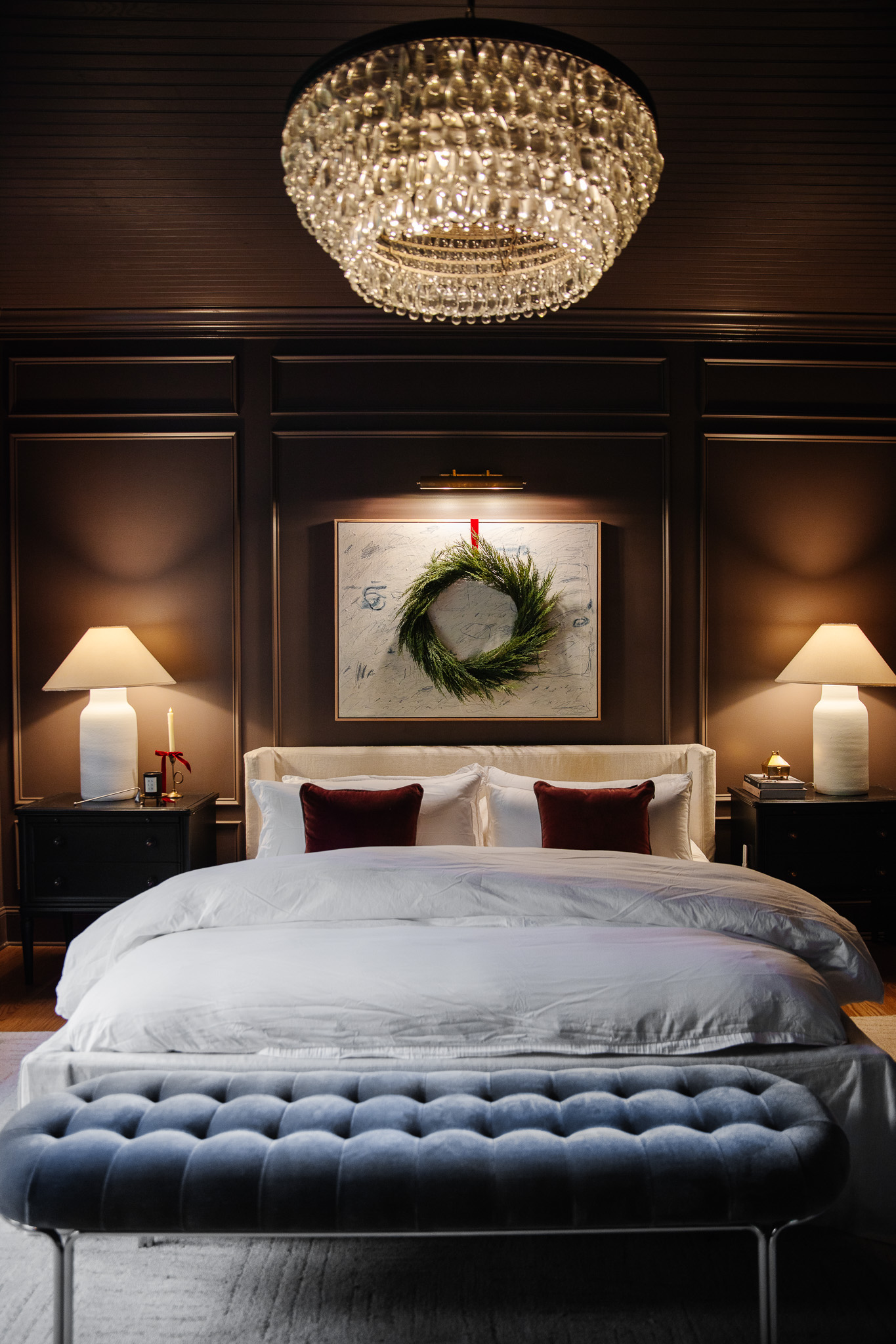 A primary bedroom with a simple wreath over the canvas that hangs over the bed