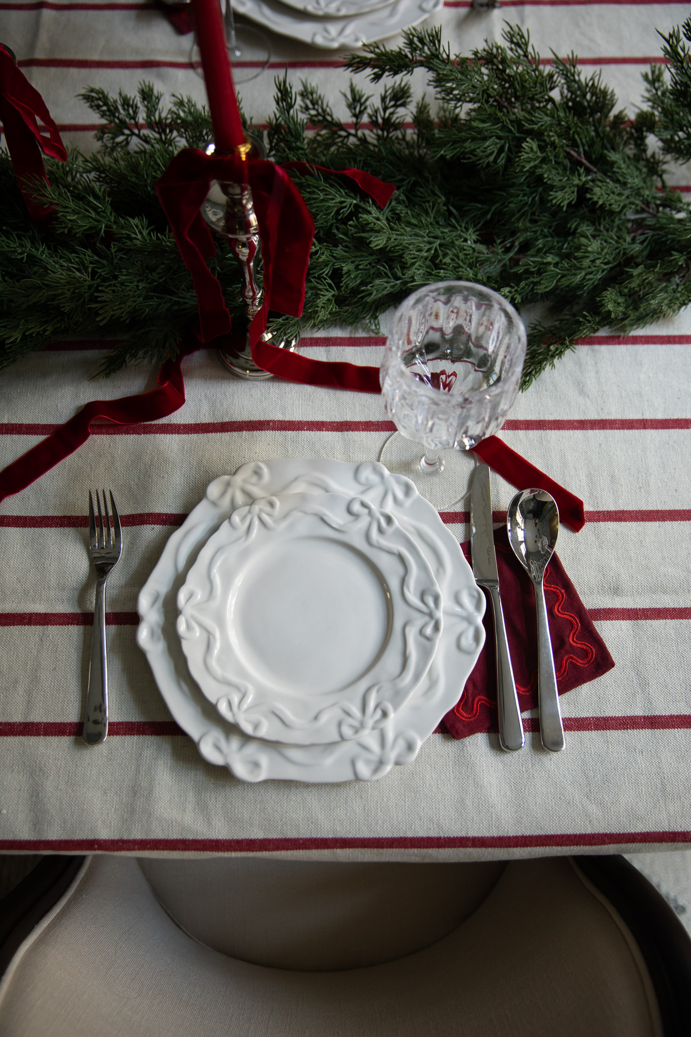 Overhead of a set of white plates and a red cocktail napkin