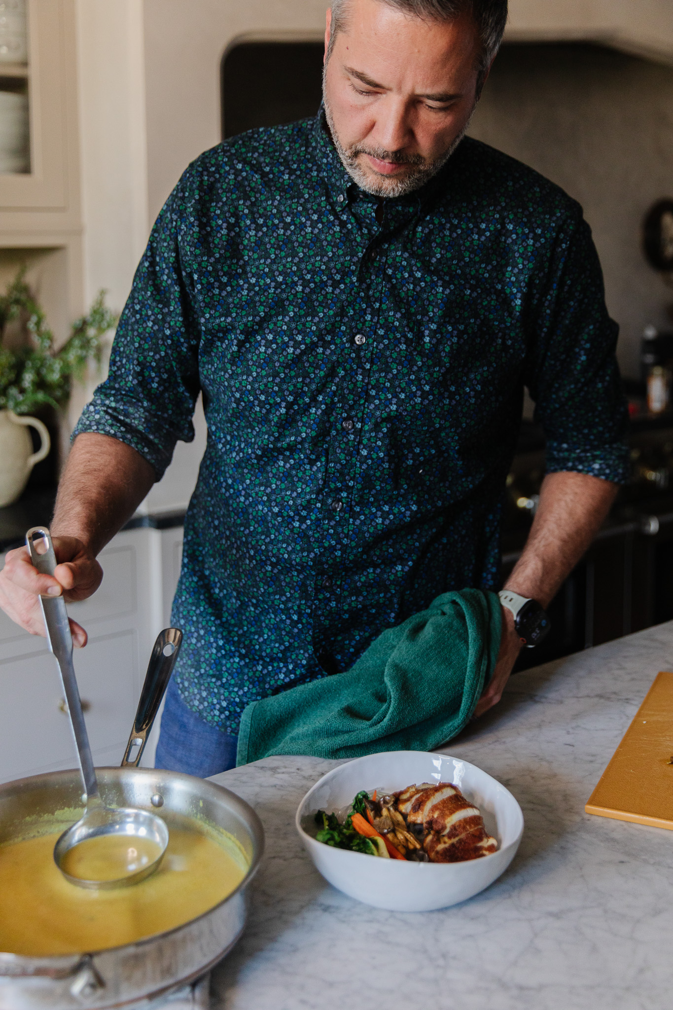 Chris scooping a ladle into coconut curry broth