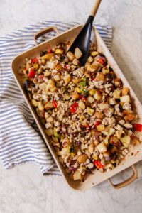 An Our Place roasting pan with breakfast hash of potatoes, cauliflower, chicken sausage, and red peppers
