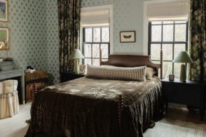 Dark green velvet bedspread on a turned wood bed in a girl's bedroom