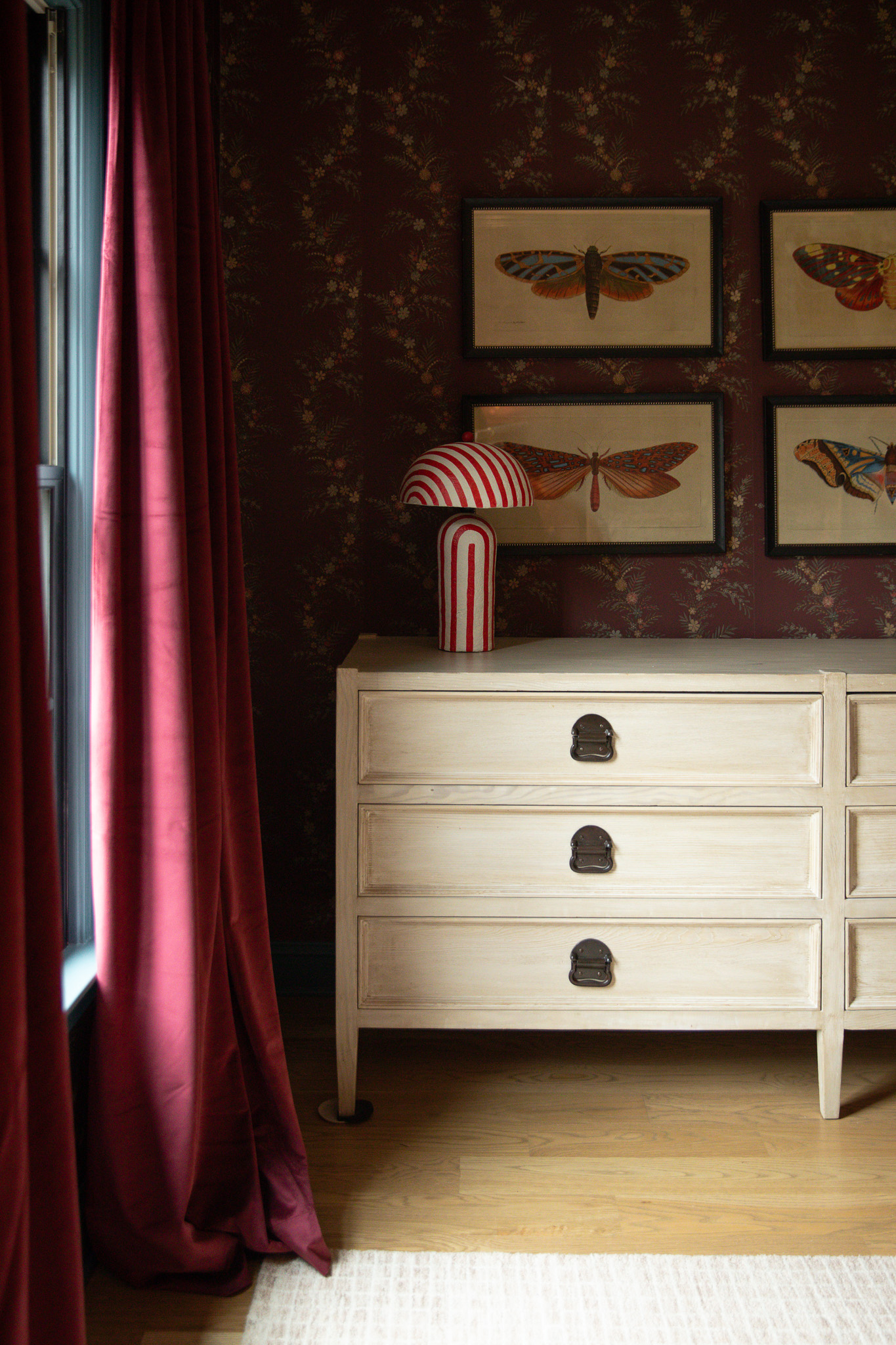 Modern red & white striped lamp on from Wayfair on a dresser 